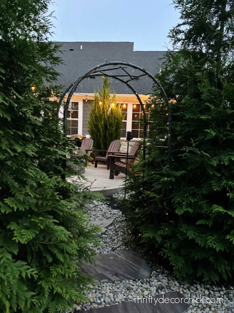 metal arbor with lights between trees